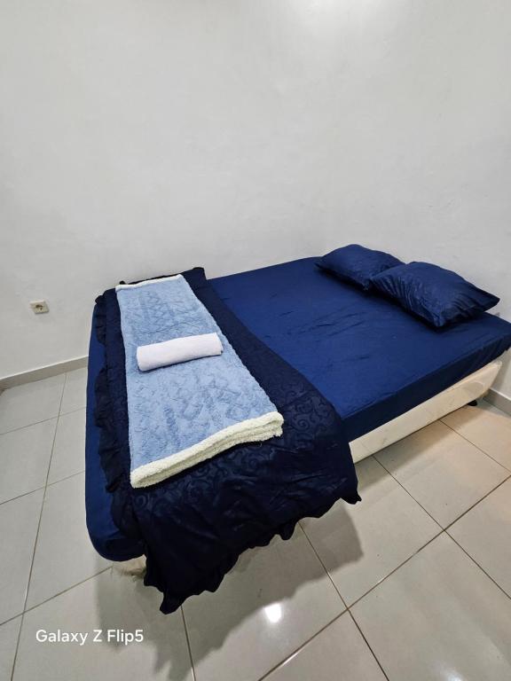 a bed with blue sheets and towels on it at Erigeron homestay dieng in Banjarnegara