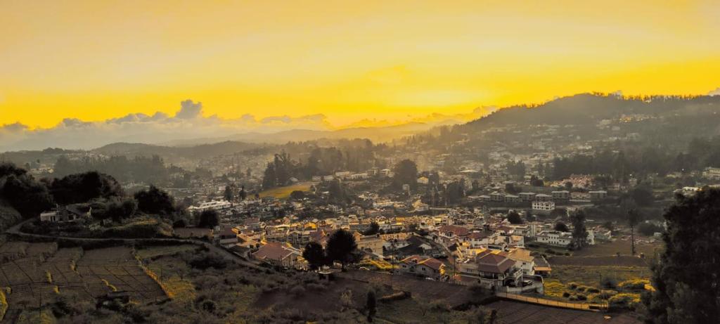 a view of a city with a sunset in the background at Angel Hollidays ooty in Ooty