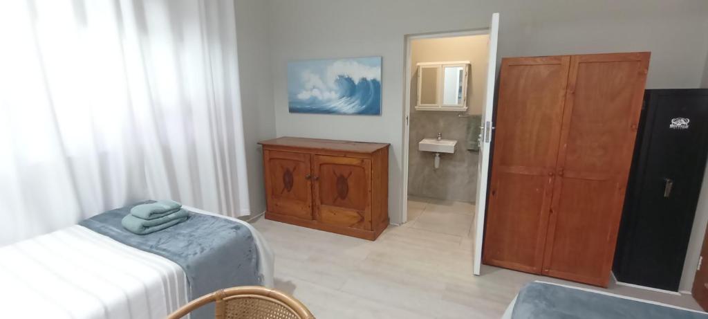 1 dormitorio con 1 cama, armario y baño en John's place, en Port Shepstone