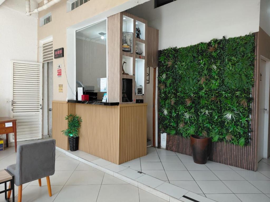 an office with a large green wall in a room at Pousada EAS Suítes Internacionais 10min GRU in Guarulhos