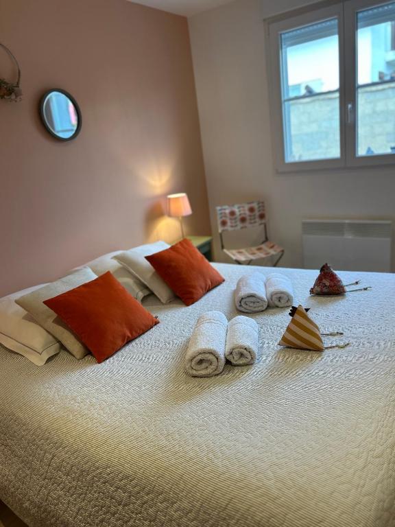 a white bed with towels and pillows on it at Côté Poules in Quesnoy-sur-Airaines