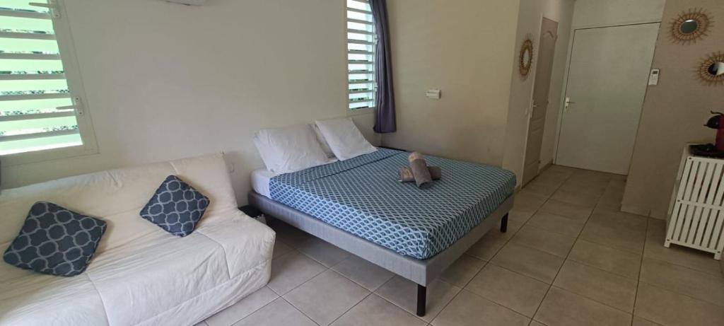 a small bedroom with a bed and a couch at Tidousè Matnik in Sainte-Anne
