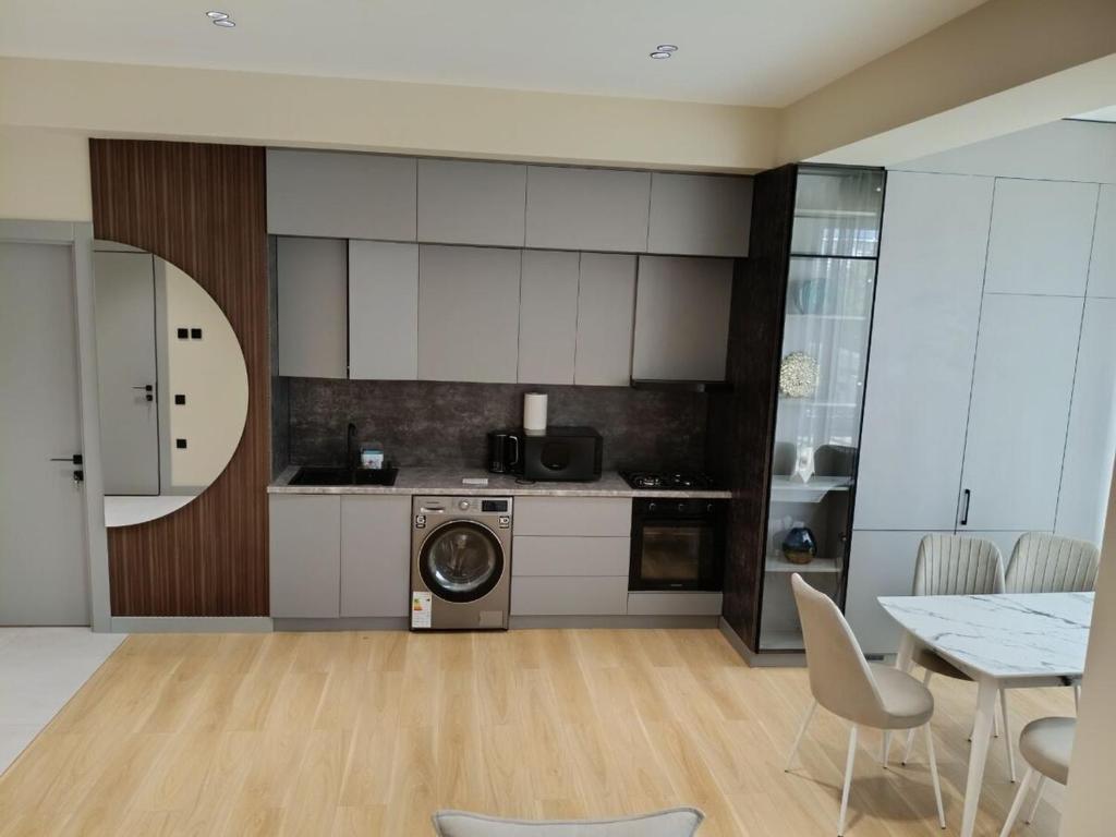 a kitchen with a washing machine and a table and chairs at Luxury Apartment Yunusabad Residence - US Embassy in Yunusobod