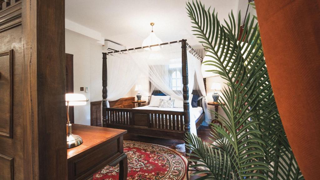 a bedroom with a bed and a plant in a room at Maprang Boutique Stay in Amphoe Koh Samui