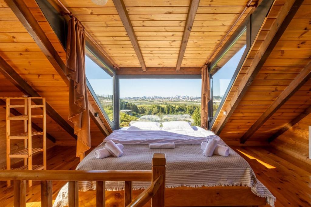 ein Bett in einem Zimmer mit einem großen Fenster in der Unterkunft Via Bungalows Batumi in Batumi