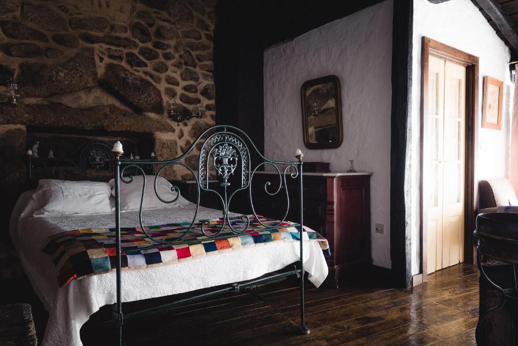 a bedroom with a bed and a stone wall at Casa dos Candeias - Apartamento Tio João in Chaves