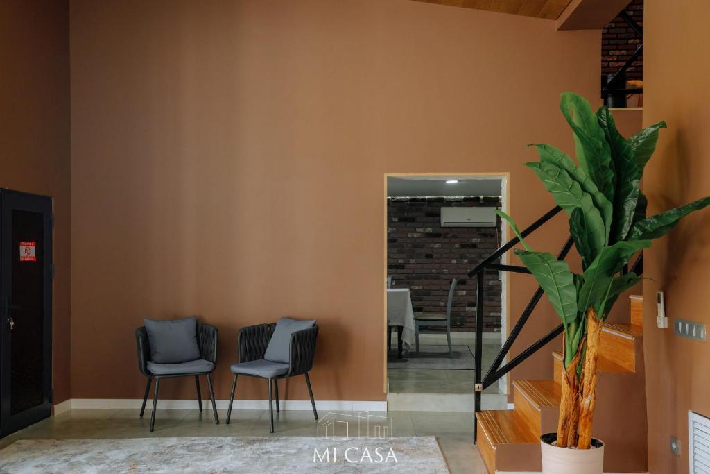 einen Flur mit zwei Stühlen und einer Pflanze in der Unterkunft Micasa residence in Schymkent