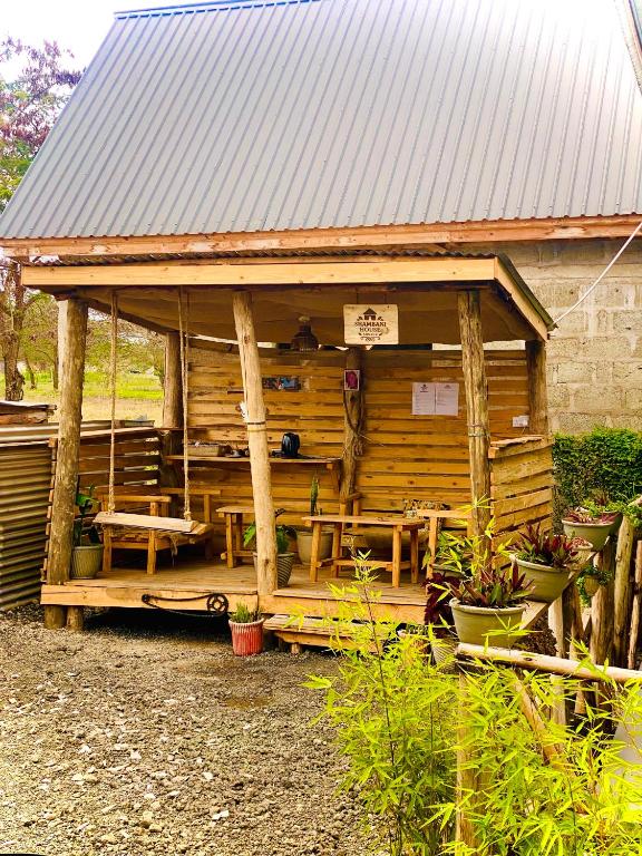a wooden cabin with a metal roof at Shambani House in Arusha