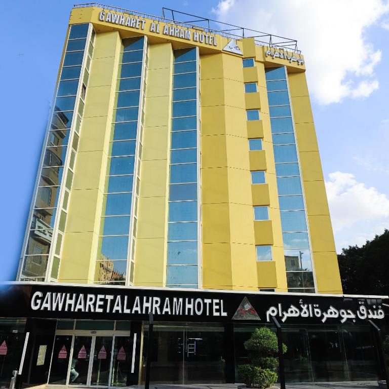 a yellow building with a sign in front of it at Gawharet Al Ahram Hotel in Cairo