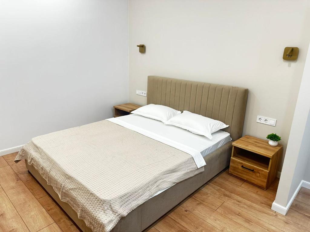 ein Schlafzimmer mit einem Bett mit weißen Laken und Kissen in der Unterkunft ЦЕНТР ГОРОДА & PERFECT APARTMENT & CENTER OF THE CiTY in Almaty