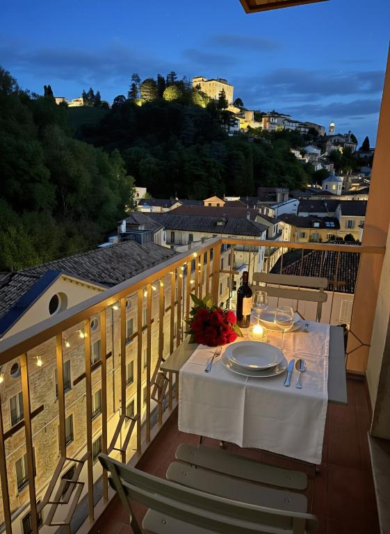 a table on a balcony with a view of a city at Canelli Wine Suites - Moscato & Barbera in Canelli