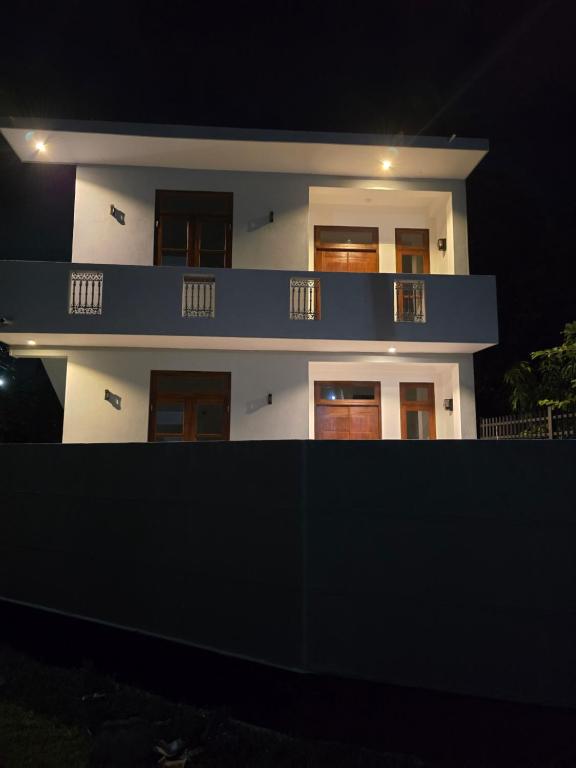 - un bâtiment blanc avec un balcon bleu la nuit dans l'établissement N A 63 Residence Transit Hotel, à Negombo