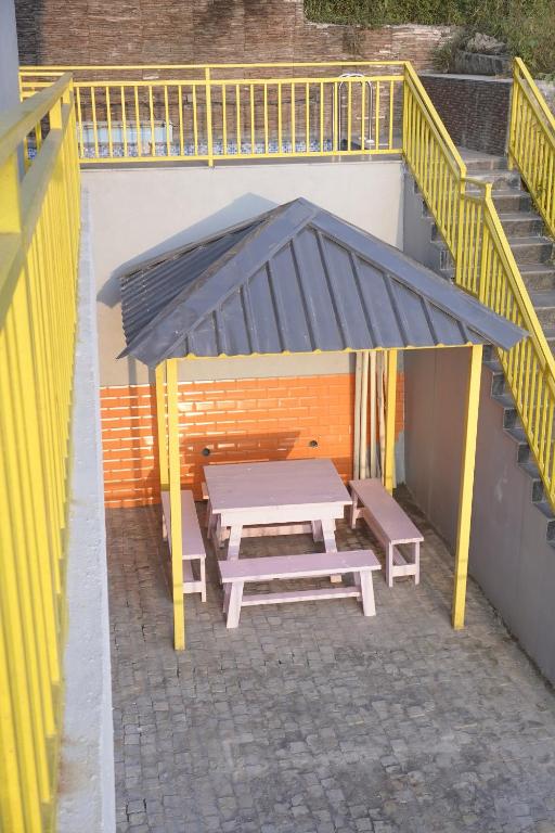 una mesa de picnic bajo un dosel en un patio en Hillshades Comfy rooms, en Dagshai