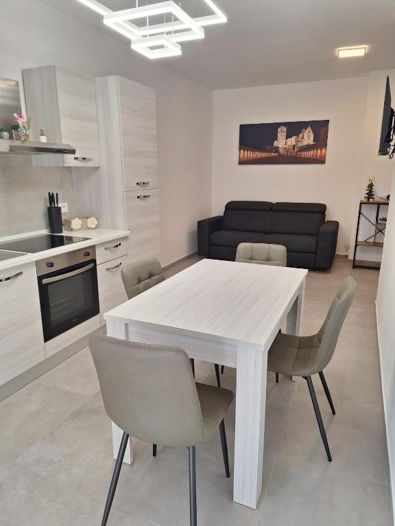 a kitchen and dining room with a white table and chairs at Il Nido a Due Passi da Assisi in Bastia Umbra