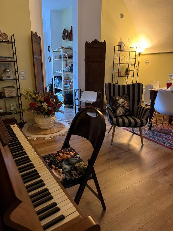 a living room with a piano and two chairs at Al Nido delle rondini 2 in Vaprio dʼAdda