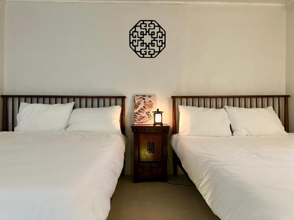 Dos camas una al lado de la otra en un dormitorio. en Arang Stay Seoul 동대문, en Seúl