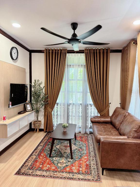 a living room with a couch and a ceiling fan at Rumah Kebun Gucher in Kuala Terengganu