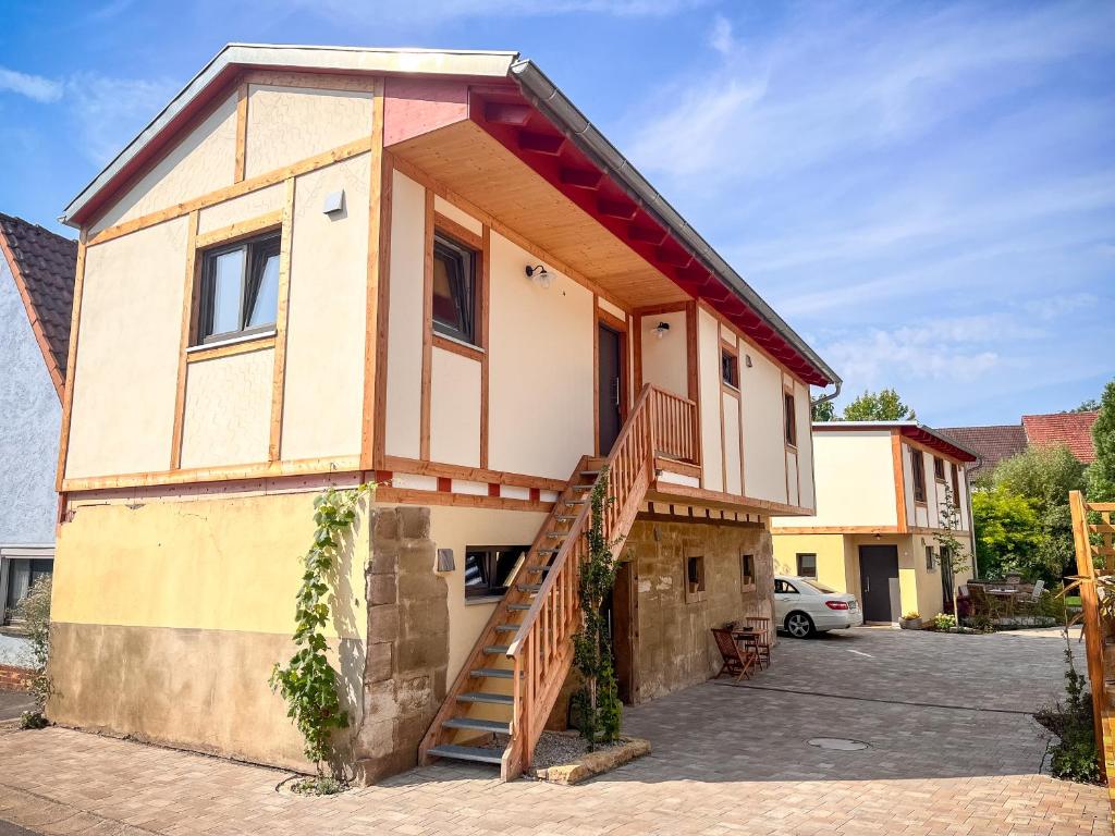 a house with a staircase in a parking lot at Ferienwohnung 'Ginkgo' mit verwunschenem Garten & privater Sauna in Hofheim in Unterfranken