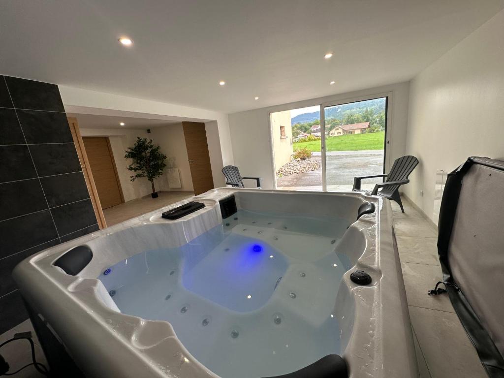 a large bath tub in a room with a large window at Nouveauté Gite la virée verte in Vagney