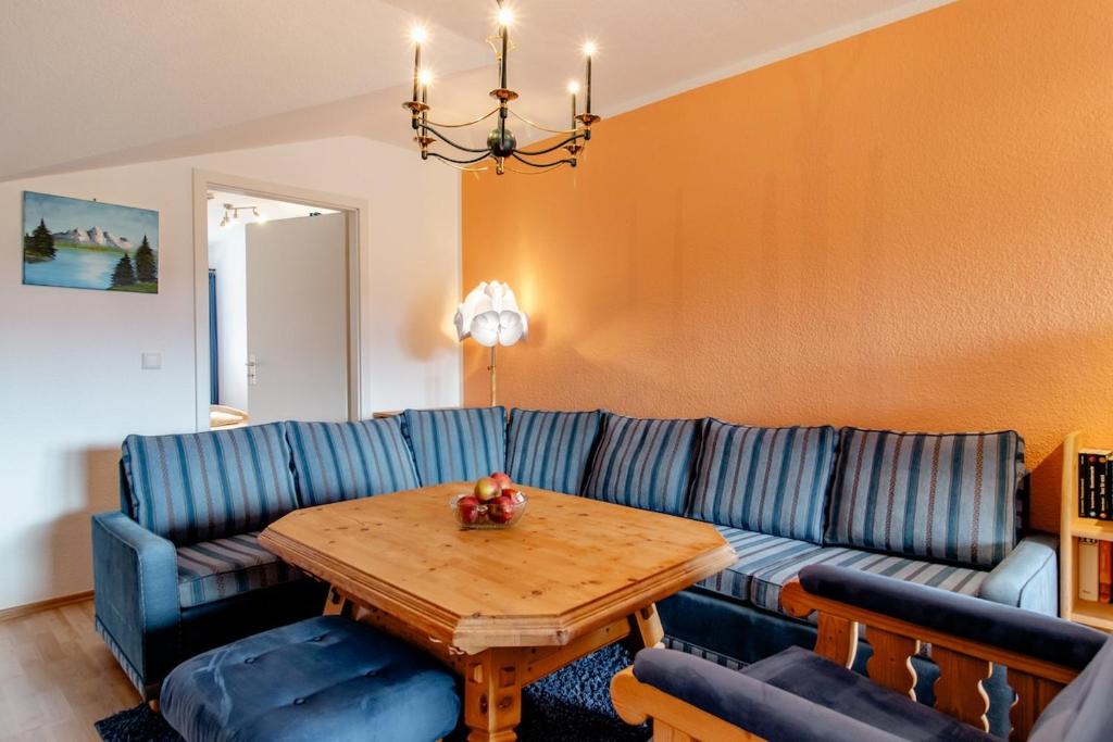 a living room with a blue couch and a wooden table at Ferienwohnung Alpenpanorama in Oberau