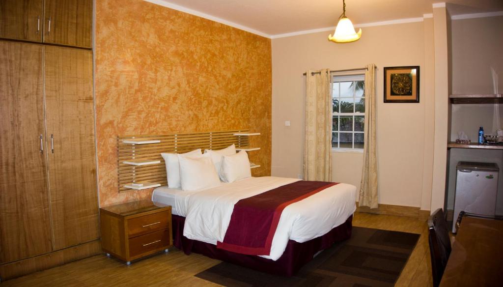 a hotel room with a bed and a window at Tropical Enclave Hotel in Accra