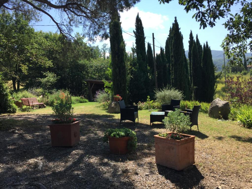 a group of chairs and tables in a garden at Podere Pinzicalari in Castel del Piano