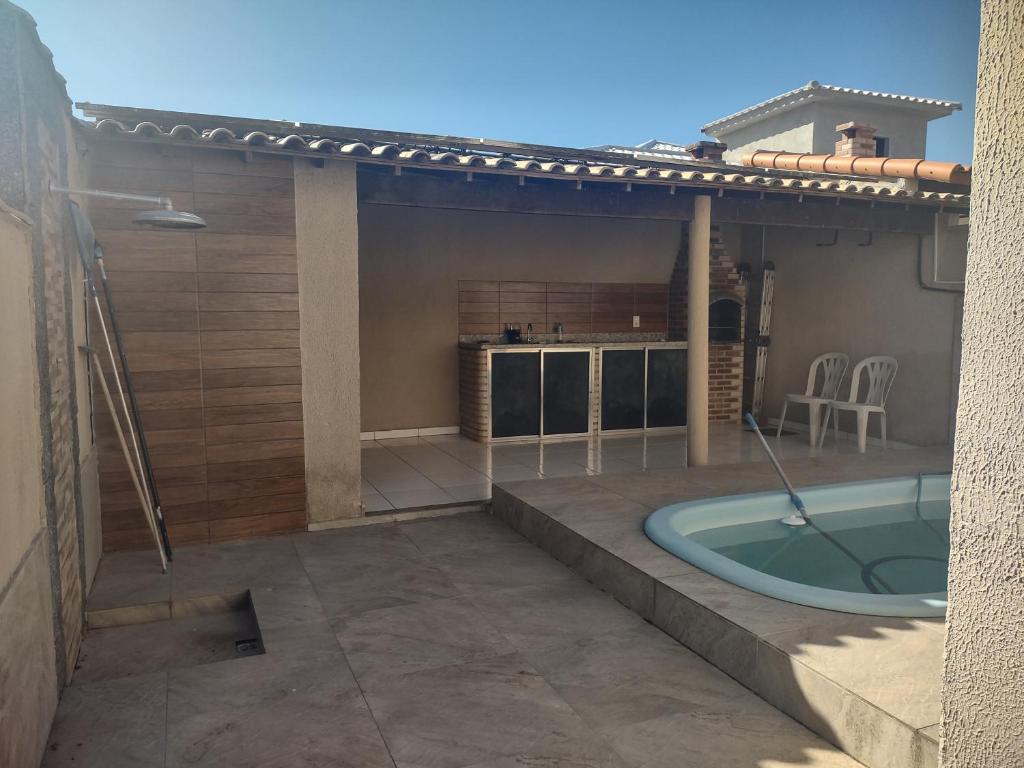 a backyard with a jacuzzi tub on a patio at Casa com 03 Quartos, Piscina e Churrasqueira em Itaipuaçu Maricá RJ in Maricá