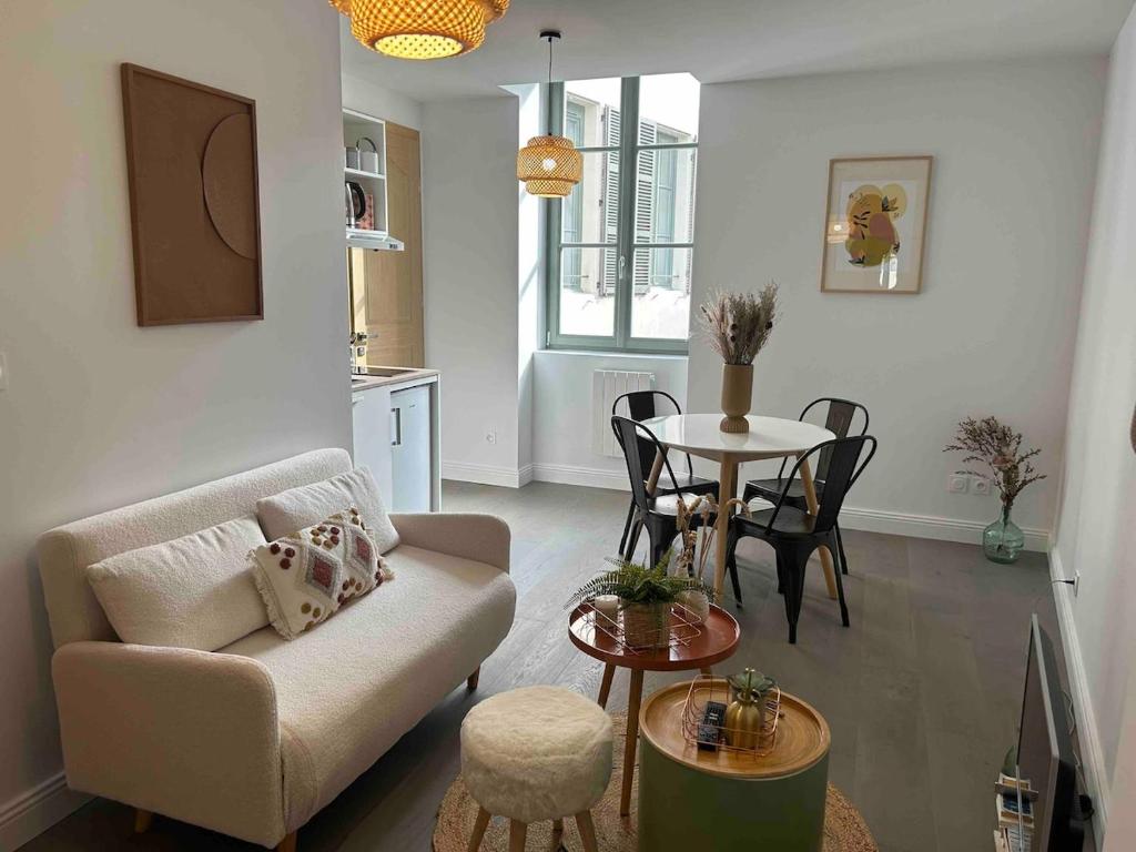 a living room with a couch and a table at Joli petit appartement plein centre in Chalon-sur-Saône