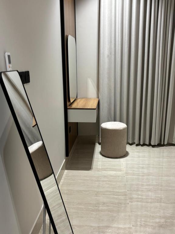 a bathroom with a mirror and a stool at شقة بحي البرج جديدة in Al Kharj