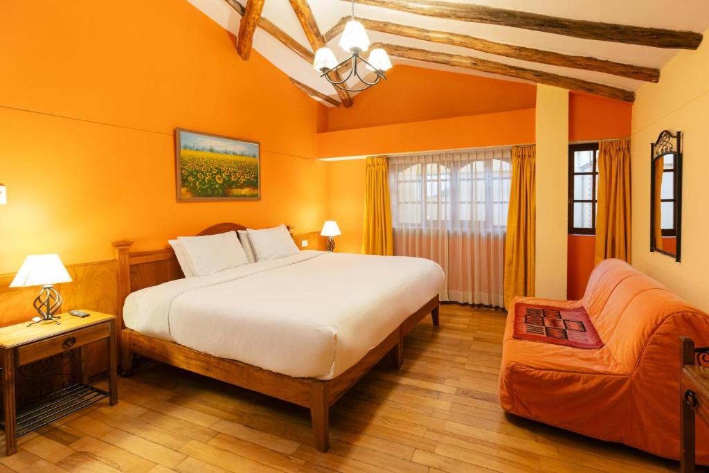 a bedroom with a large bed and a couch at Amerindia in Cusco
