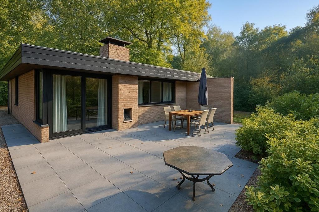 a patio with a table and chairs and a house at Zenda's natuurhuisje in Lanaken