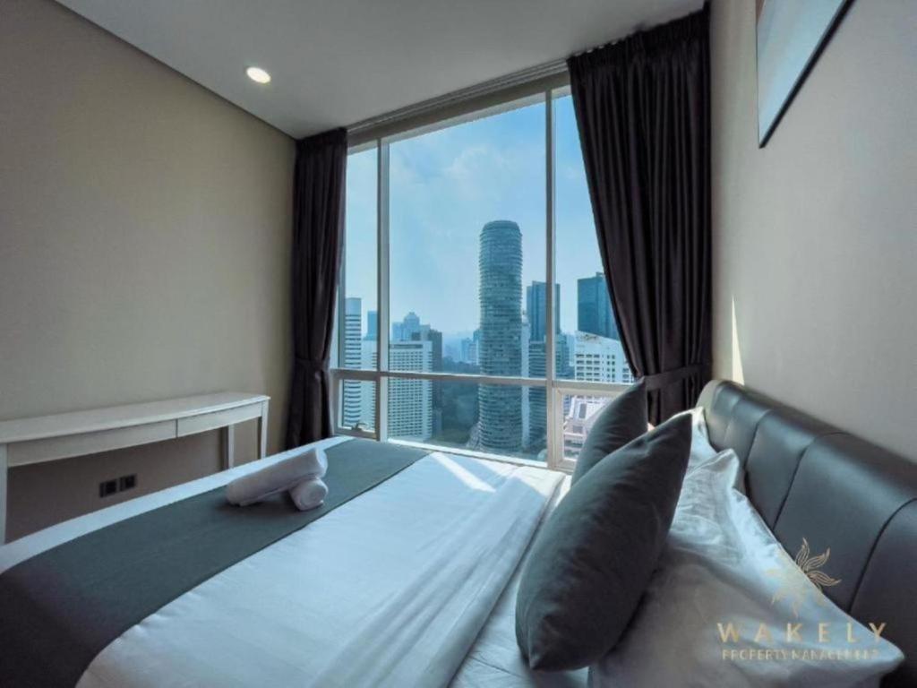 a bedroom with a bed with a large window at Sky Suites KLCC CityLights in Kuala Lumpur