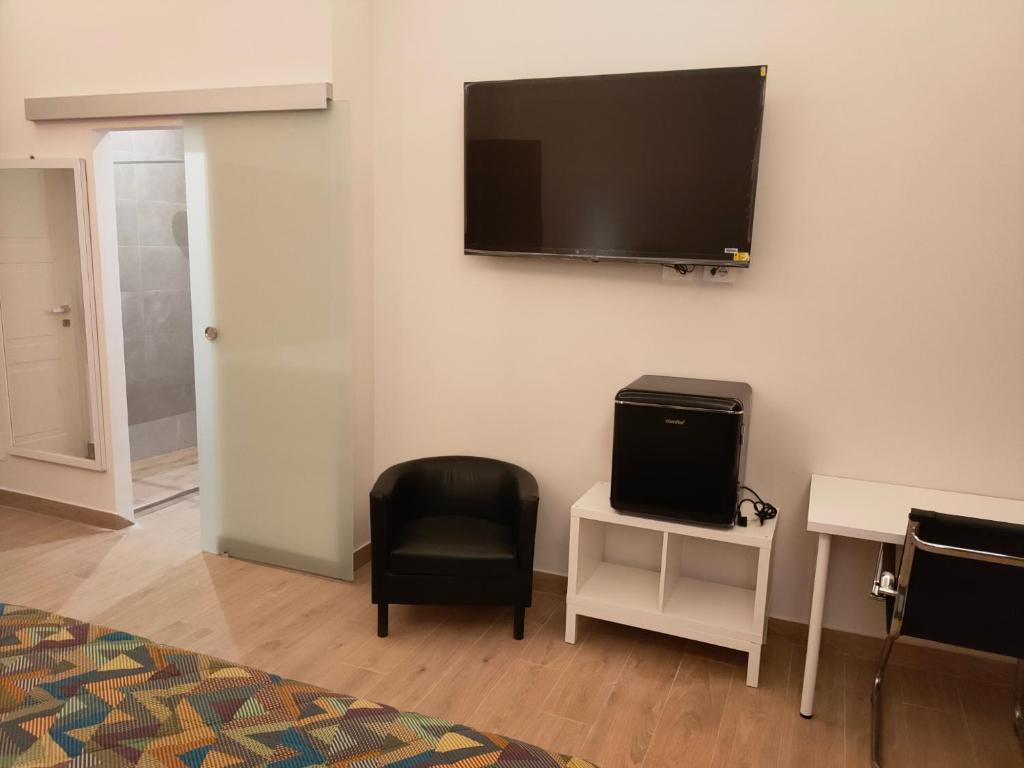 a room with a tv on the wall with a chair at Igg VATICAN HOLIDAY in Rome