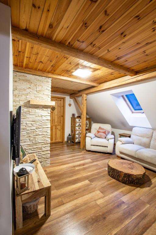 a living room with two couches and a stone fireplace at Chalet Malá Strana in Lučany nad Nisou