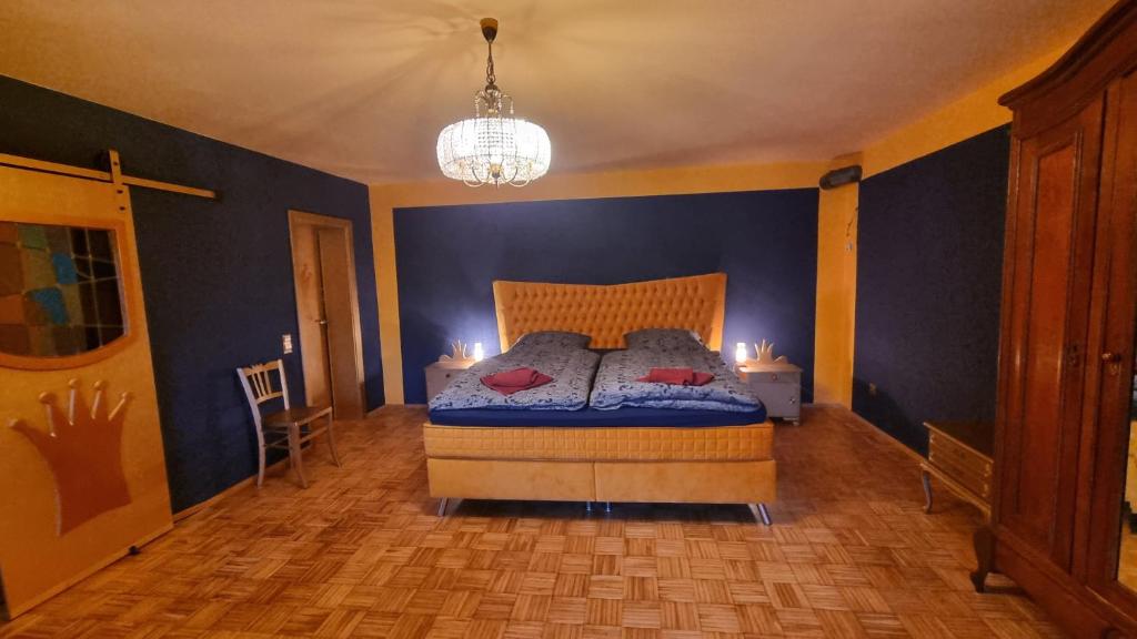 a bedroom with a bed with blue walls and a chandelier at Casa Moselle-Royal Stilvoll Urlauben an der Mosel in Reil