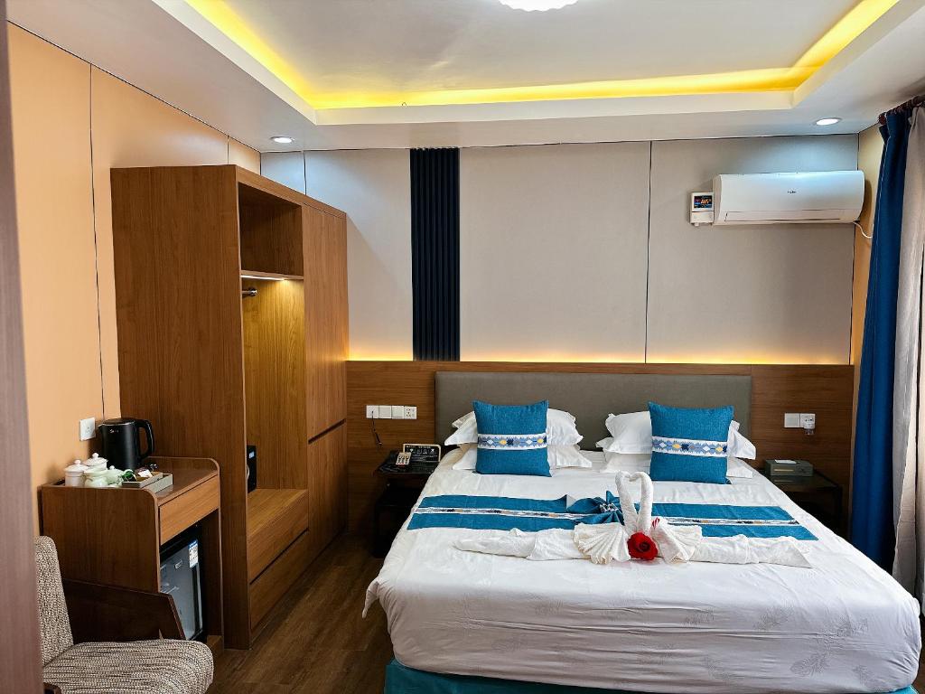 a bedroom with a large bed with blue pillows at Nanjing Restaurant & Motel in Kampala