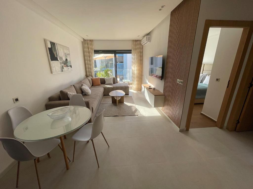 a living room with a couch and a table and chairs at Modern Coastal Apartment in Kenitra