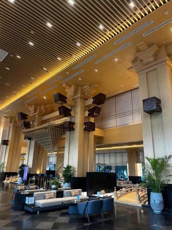 un grand hall avec des tables et des chaises dans un bâtiment dans l'établissement Wyndham Lynn Times Thanh Thuỷ - Căn hộ khách sạn Onsen 5 sao, à La Phu