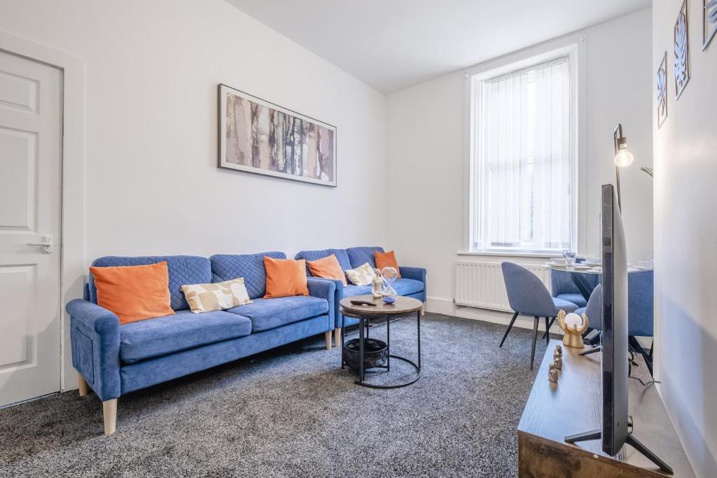 a living room with a blue couch and a table at Contractors! Free parking, Wifi, 6 BDR, 10 Beds! in Elswick