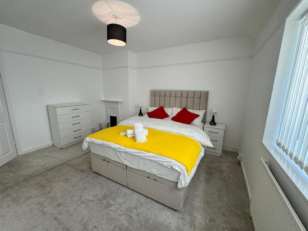 バーミンガムにあるEntire home in Perry Bar,Birmingham,United Kingdomのベッドルーム1室(黄色いシーツと赤い枕のベッド1台付)