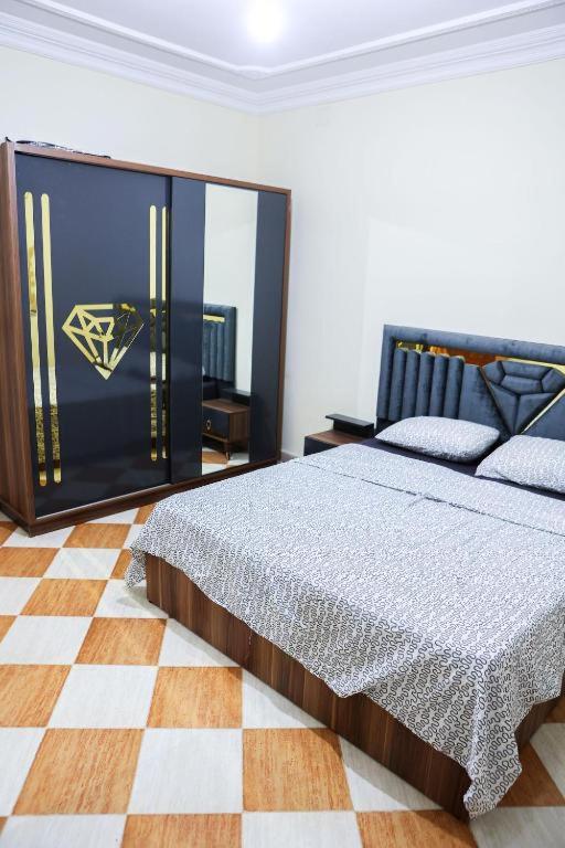 a bedroom with a bed and a checkered floor at najmatriff in Driouch