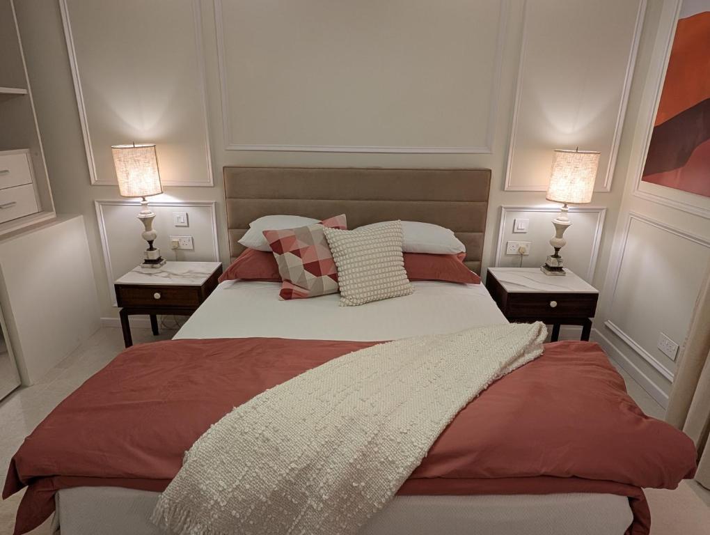 een slaapkamer met een bed met 2 nachtkastjes bij Mahogany - Rooftop Views - Close to Valletta Ferry in Senglea