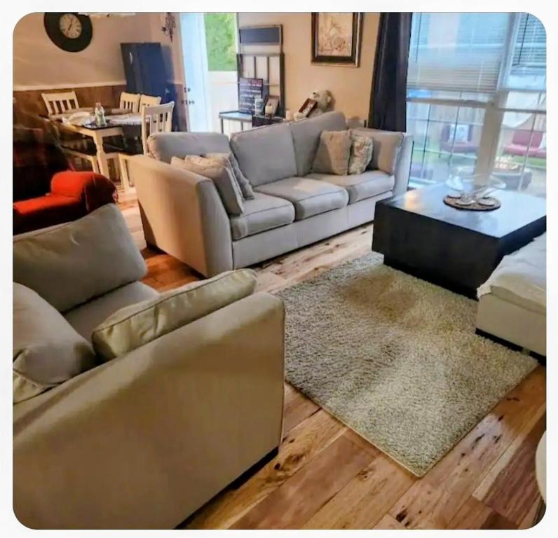 a living room with two couches and a table at Your Temporary Haven in La Vergne