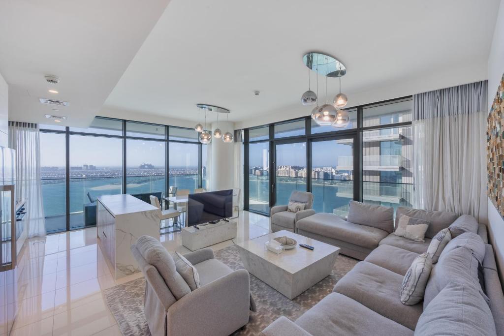 a living room with a couch and a tv at Sea View with Private Beach Access! 3BR & Maid Rm in Dubai