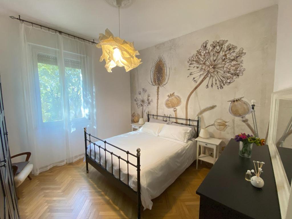 een slaapkamer met een bed, een tafel en een kroonluchter bij Malmusi Apartment in Modena