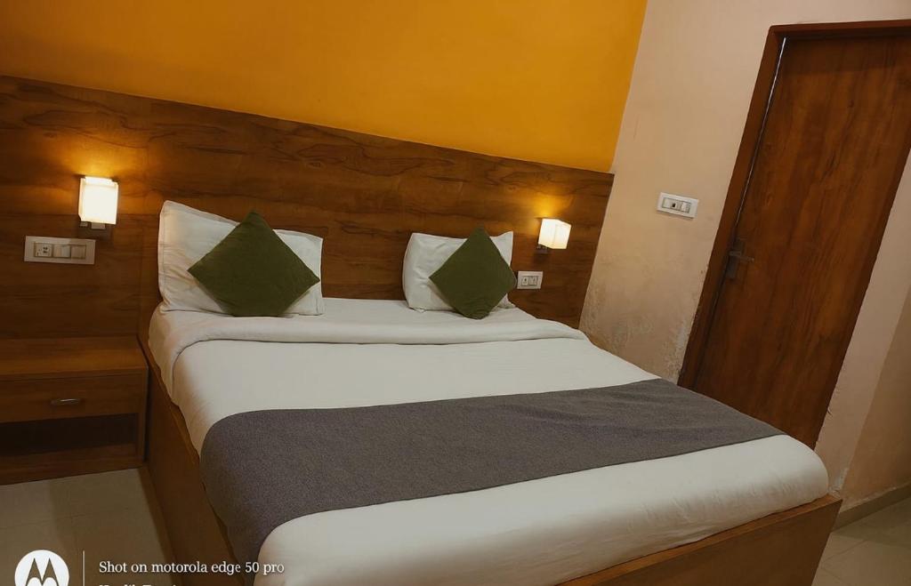 a bedroom with a large bed with green pillows at The Silverkey Hospitalilty - Krishiv palace Hotel in Vrindāvan