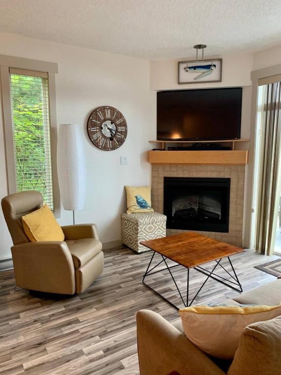a living room with a fireplace and a tv at Sooke Harbour Hideaway - Luxurious Vacation Rental in Sooke