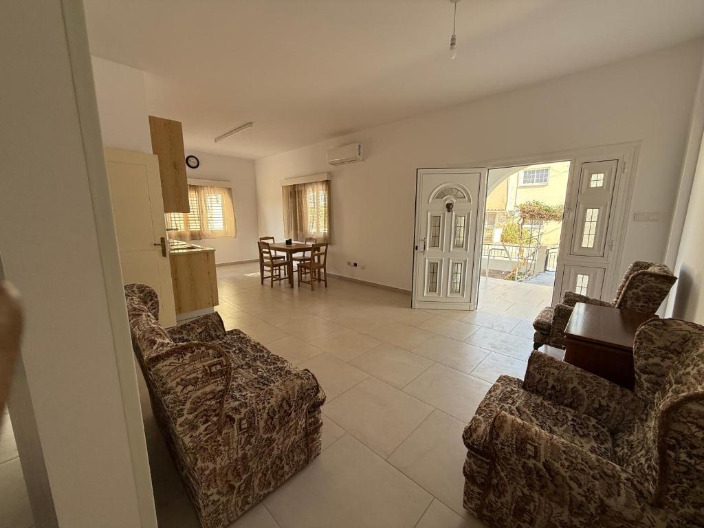 ペリヴォリアにあるCozy 2BR in Pervolia Near Beach Free Parking and many moreのリビングルーム(椅子2脚、テーブル付)、キッチン