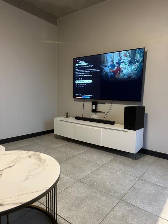 ein Wohnzimmer mit einem großen TV an der Wand in der Unterkunft The luxury IN waterfall Midrand in Midrand