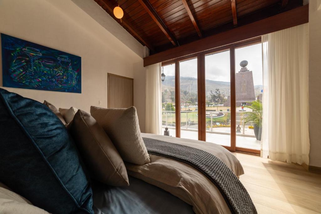 a bedroom with a bed and a large window at Hotel Boutique Mitad Del Mundo in Quito